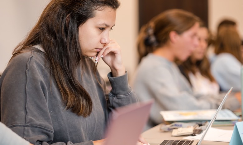 Girl viewing a laptop computer screen in class