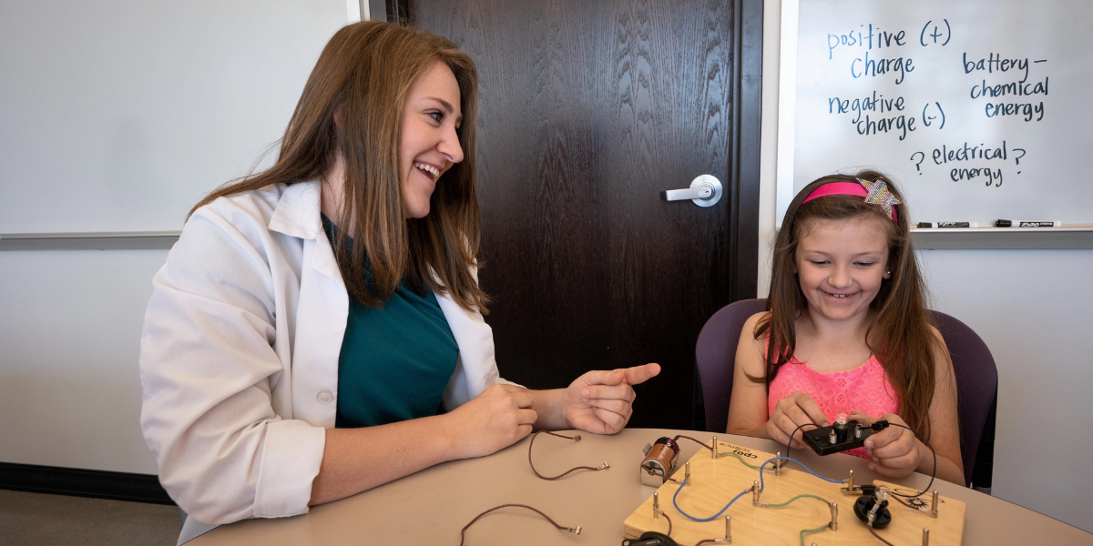 teacher and young girl with circuit board