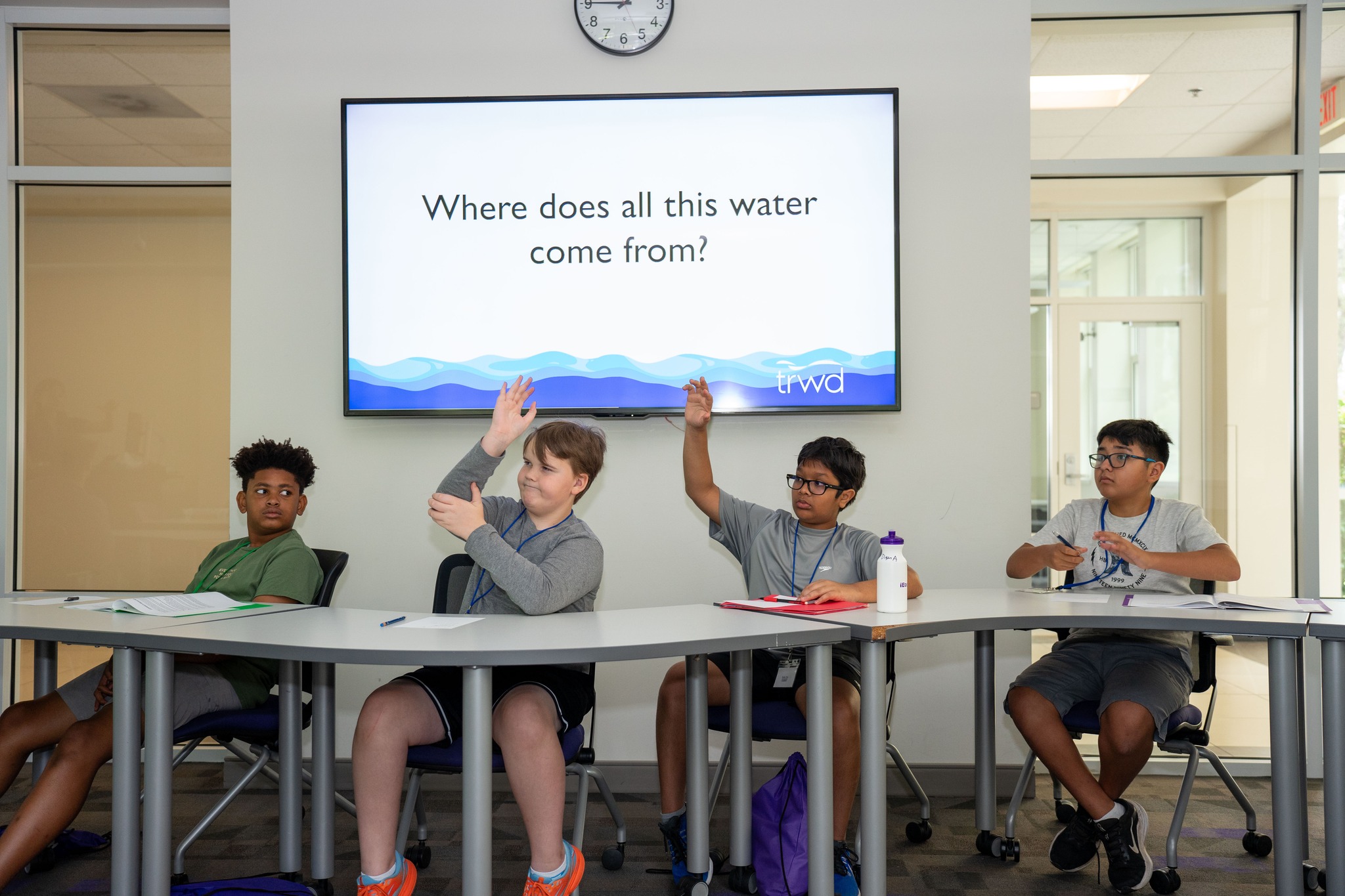 iengage students raising hand in front of tv display "where does this water come from?"