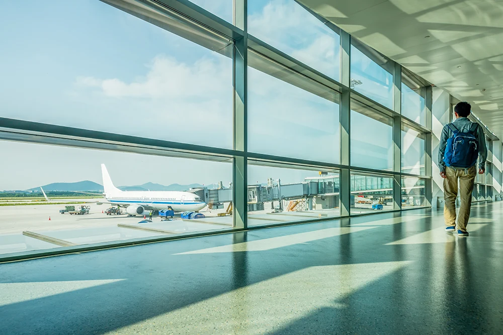 A view of an airplane taking off from inside an airport.