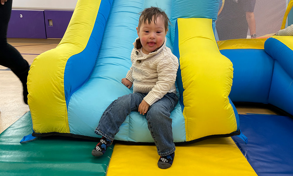 boy in white sweater on slide