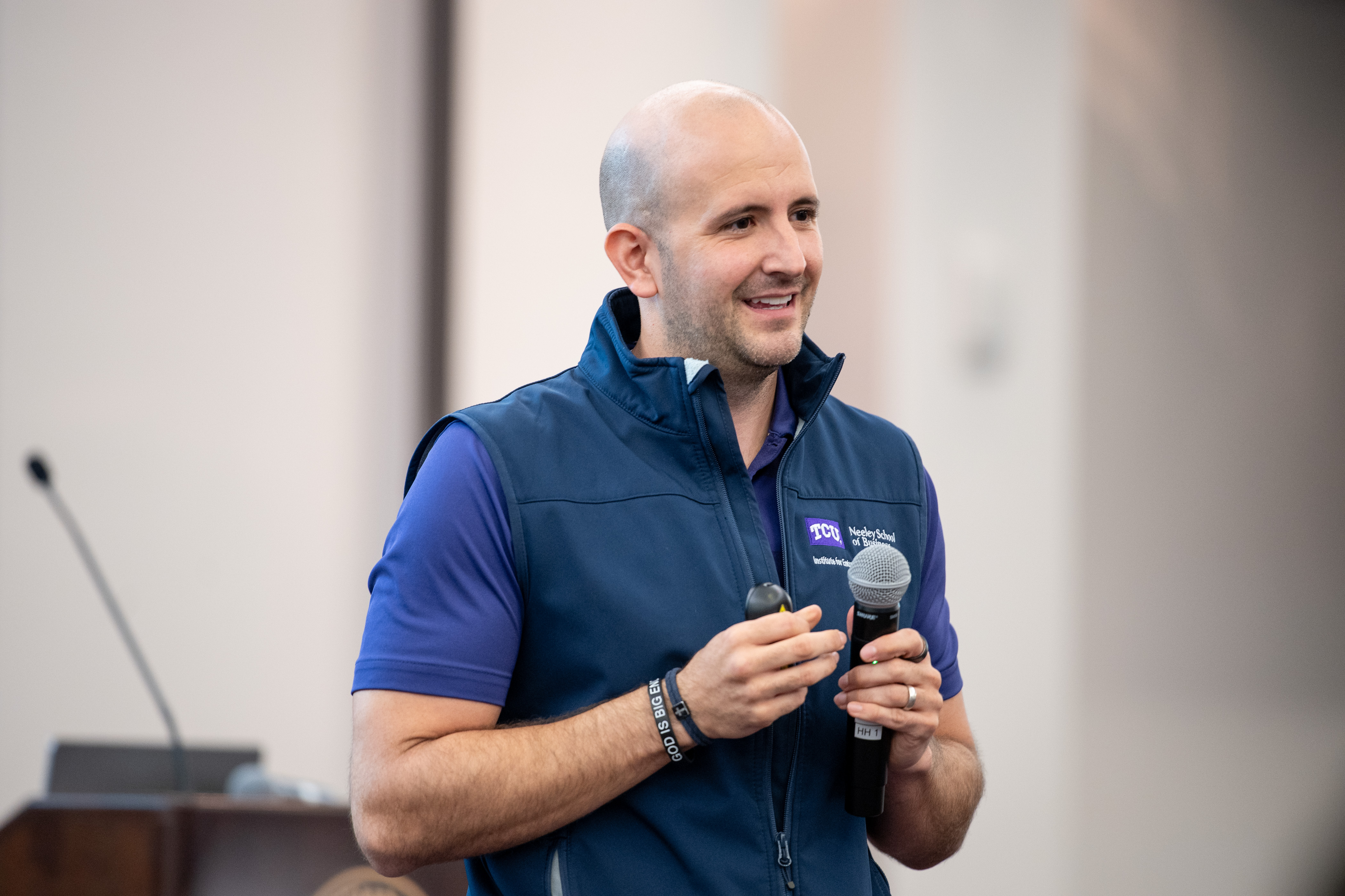 Antonio Banos presenting at the MAESTRO Conference. He wears a blue t-shirt underneath a TCU Neeley School of Business vest.