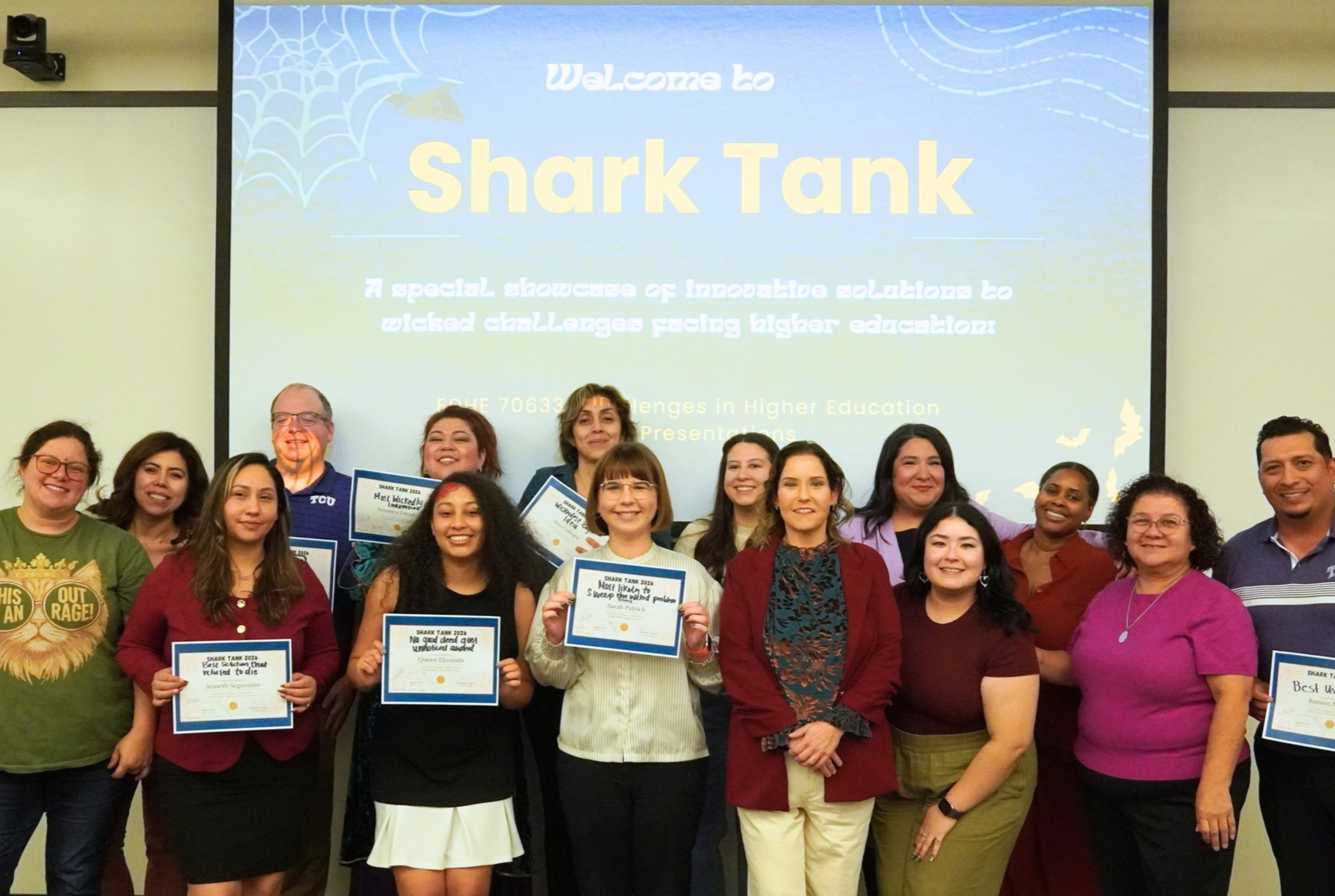 A group of individuals stand smiling in front of a 