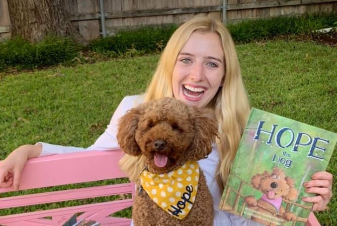 Allison Davis and her dog, Hope, with a copy of her book