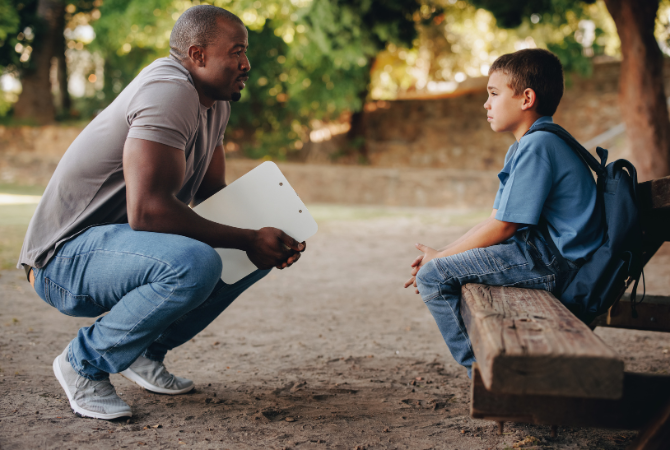 School teacher motivating a troubled school kid outside class