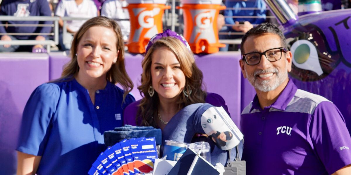 teacher of the year kristy butler smiling with gift basket presented by EECU representative and Dean Frank Hernandez