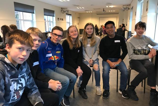 James Sang sits with a group of students while teaching in Denmark